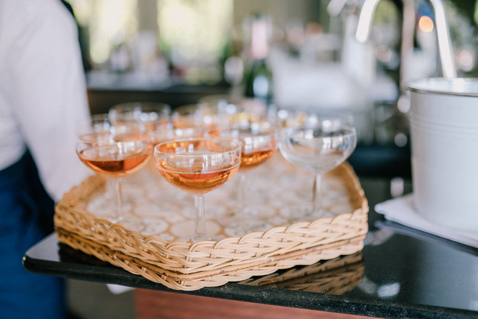 Tablett mit Coupé-Gläsern voller Rosé/Sekt als Welcome-Drink beim Firmenempfang.